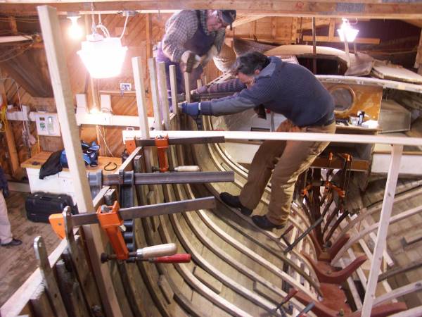 Pulling the ribs in place for a new boat built the traditional way